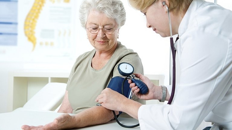 Zdravnica meri tlak pacientki.